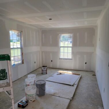 image of dry wall in home project with ladder and paint buckets