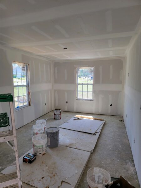 image of dry wall in home project with ladder and paint buckets